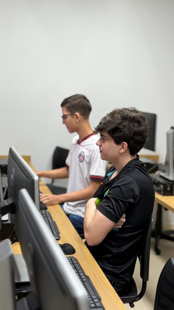 Dois jovens estudantes concentrados produzindo no computador no laboratório da NORD