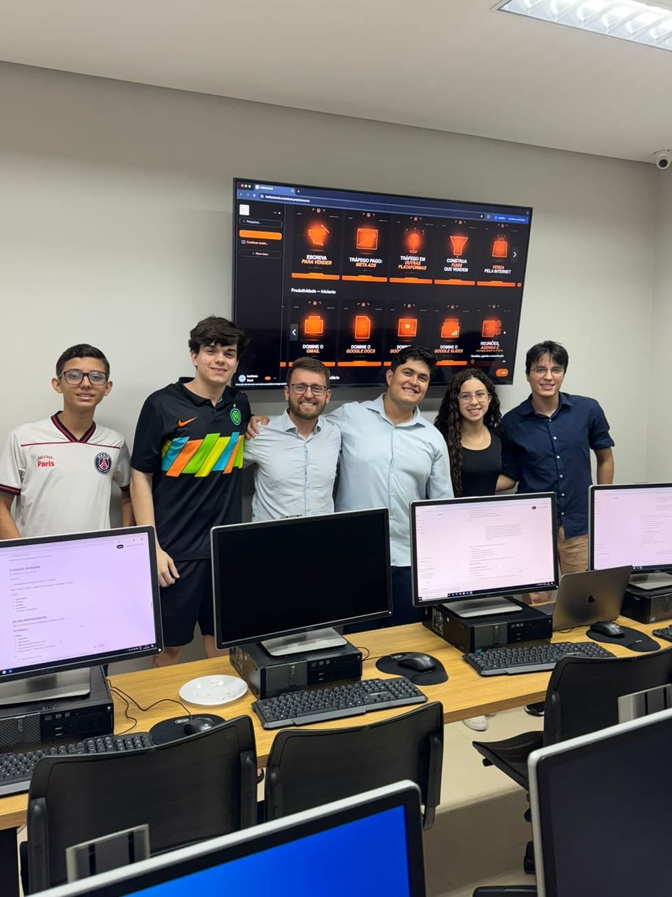 Grupo de alunos jovens e instrutores do Instituto NORD reunidos e sorrindo no laboratório
